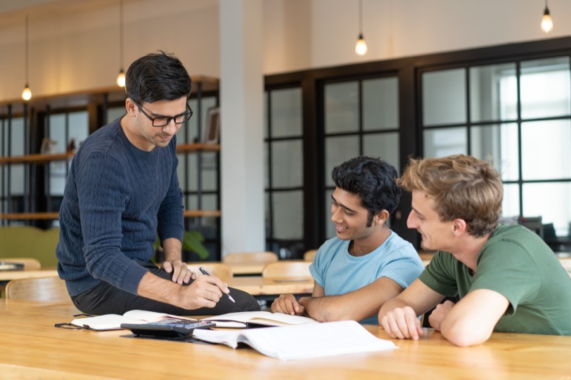 A teacher reviewing coursework with two Transition Year students