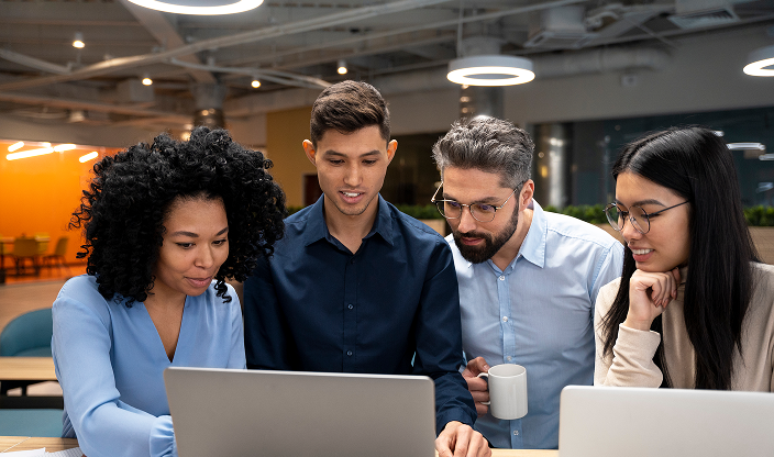 Team collaborating around a laptop